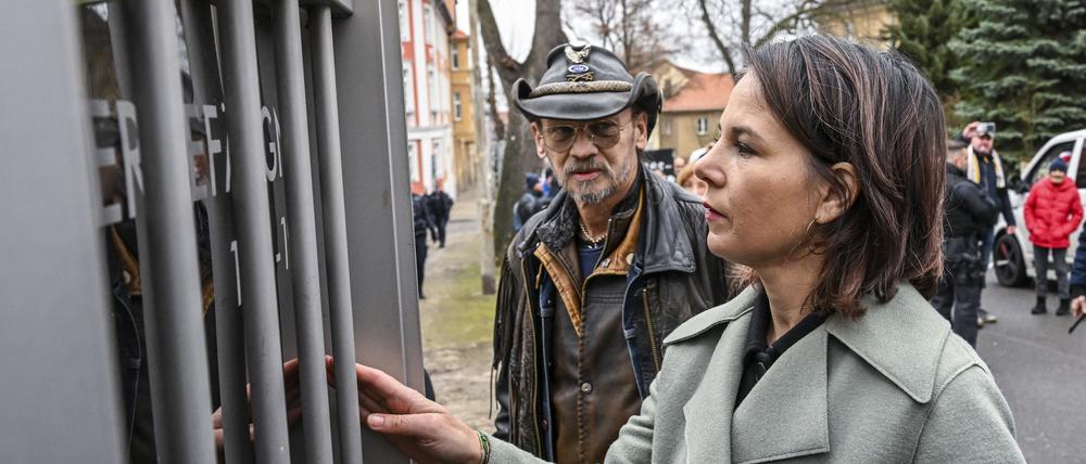 Bundesaußenministerin Annalena Baerbock (Bündnis 90/Die Grünen) steht bei einem Besuch des sogenannten Kindergefängnisses aus DDR-Zeiten mit dem Betroffenen Roland Herrmann am Mahnmal vor der Einrichtung.