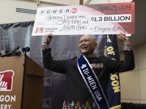 29.04.2024, USA, Salem: Cheng „Charlie“ Saephan hält einen übergroßen Scheck über seinen Kopf, nachdem er auf einer Pressekonferenz in der Lotteriezentrale von Oregon in Salem, Oregon, bekannt gegeben hat, dass er einer der Gewinner des Powerball-Jackpots in Höhe von 1,3 Milliarden US-Dollar (etwa 1,21 Milliarden Euro) ist.